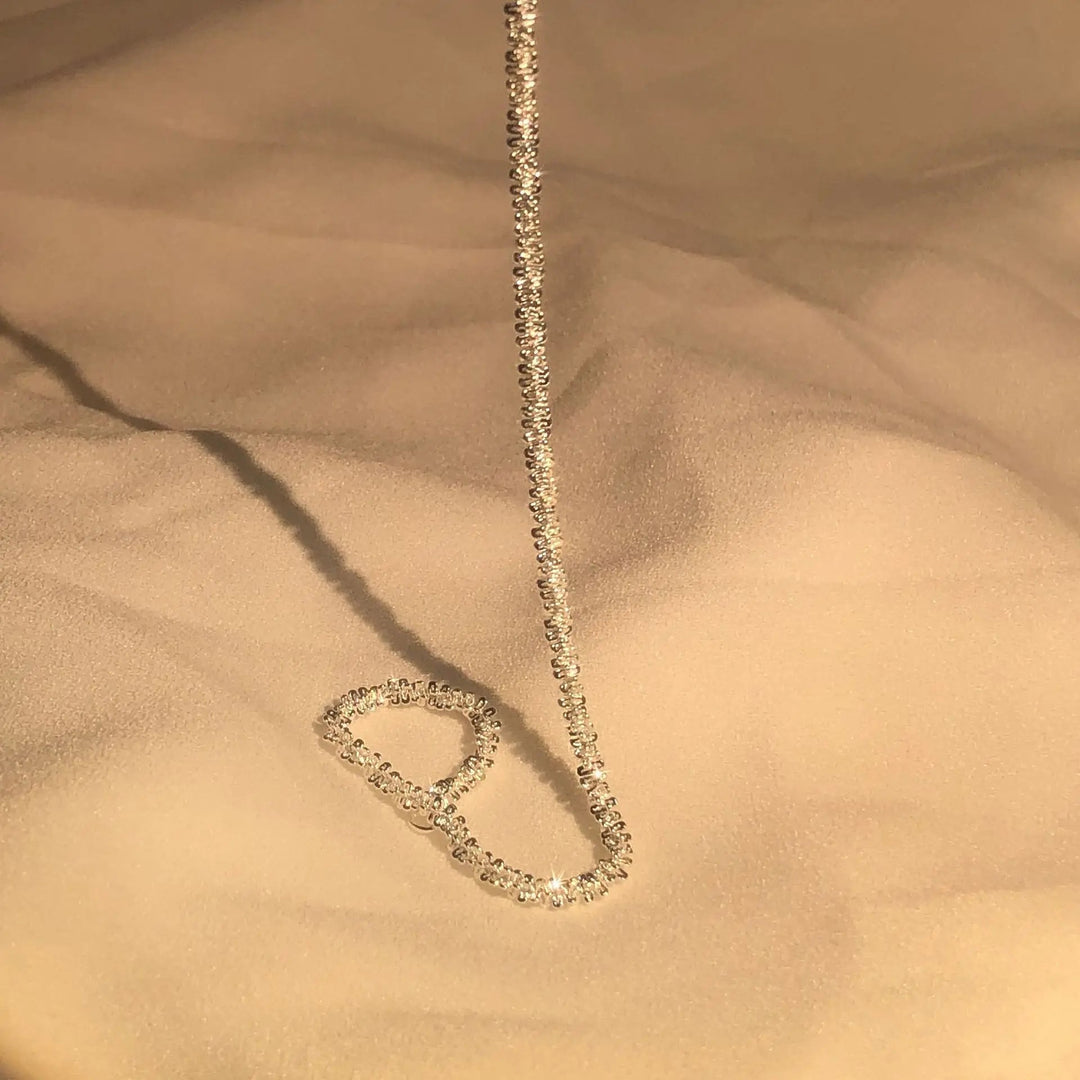 Goldene Halskette mit funkelnden Diamanten auf beigem Stoff, eleganter Schmuck für Damen.