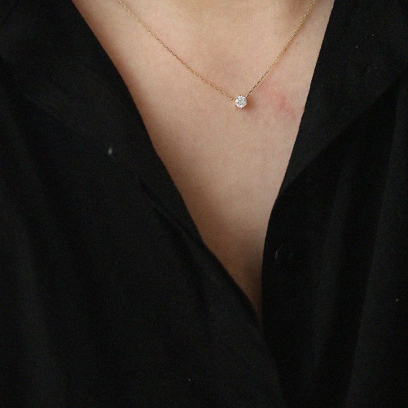 Goldene Halskette mit Diamantanhänger auf schwarzem Hintergrund, eleganter Schmuck für Damen.