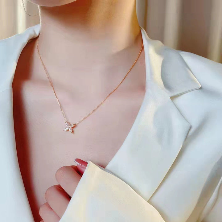 Frau trägt elegantes weißes Blazer-Outfit mit zartem, funkelndem Moissanit-Halskette.