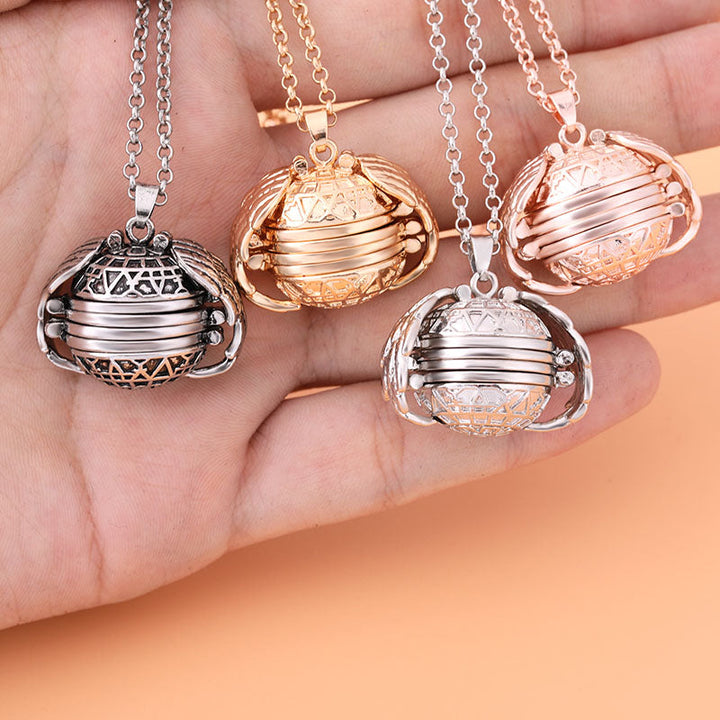 Vier rotierende Halsketten-Anhänger in Silber, Gold, Roségold auf Hand, filigranes Design.