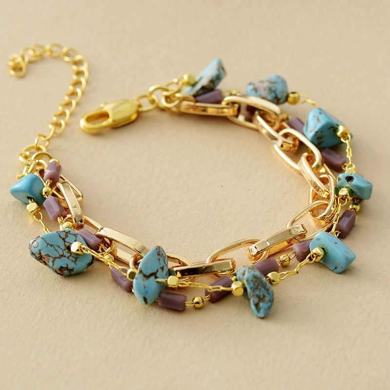 Goldenes Armband mit türkisfarbenen Steinen und Kettengliedern, modisches Schmuckstück.