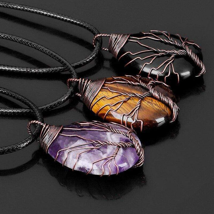 Drei handgemachte Tropfen-Halsketten mit Tigerauge, Amethyst und Onyx auf schwarzem Hintergrund.