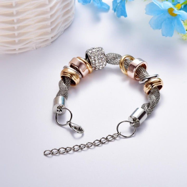 Verflochtenes Modearmband mit goldenen und silbernen Ringen, ideal als elegantes Schmuckaccessoire.