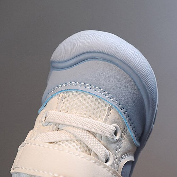 Weiße und blaue Kinderschuhe aus Leder mit Netzstoff, rutschfeste Sohle.