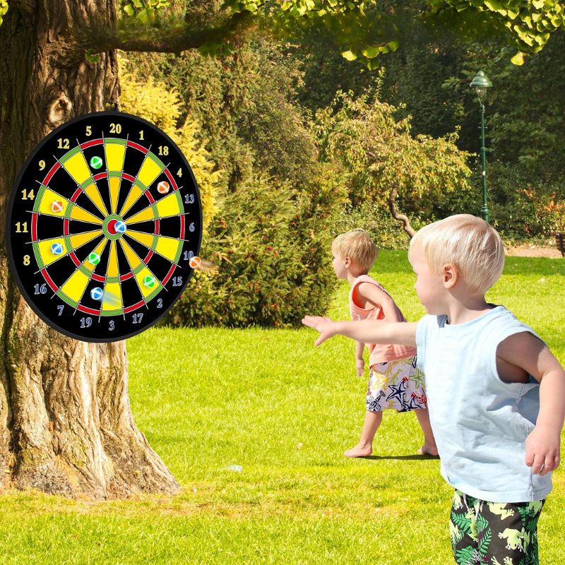 Kinder spielen mit einer Dartscheibe im Freien, befestigt an einem Baum, sonniger Tag, Sommer.