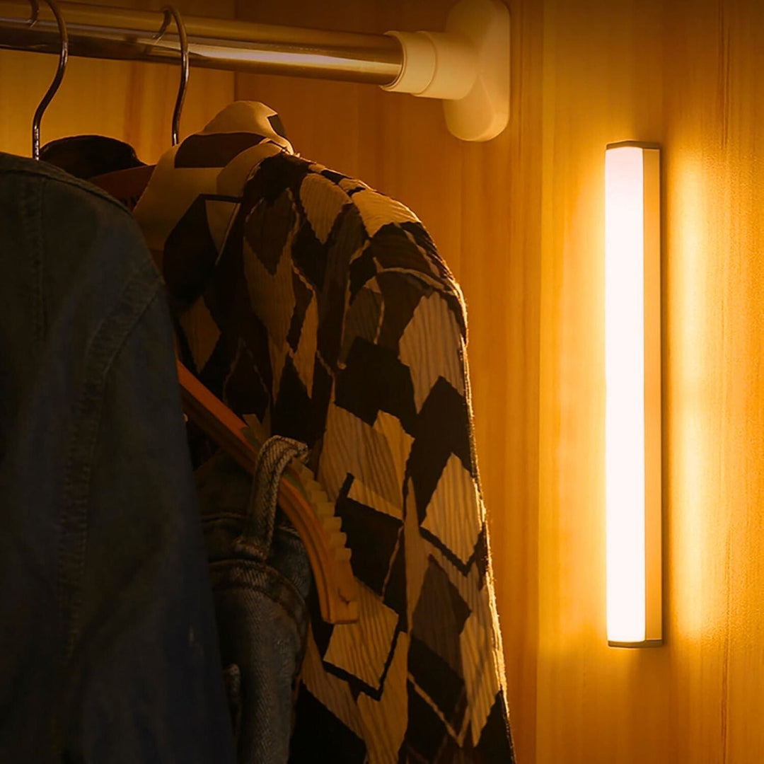LED-Schrankleuchte beleuchtet Kleidung, Holzschrank, moderne Innenbeleuchtung, energiesparend.