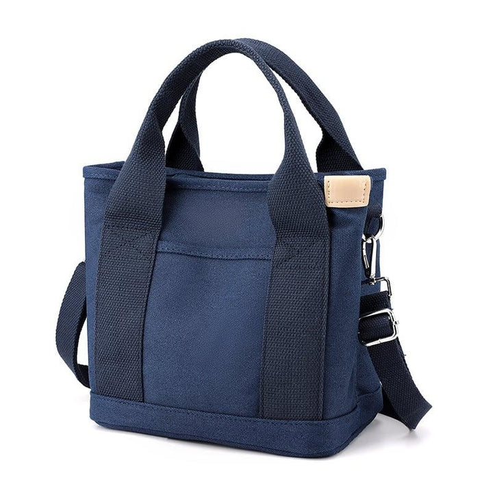 Dunkelblaue Canvas-Umhängetasche für Damen, klein, mit verstellbarem Riemen und Lederdetail.