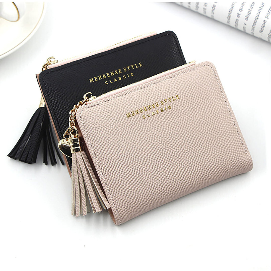 Zwei elegante Mini-Kartenetuis aus Leder, schwarz und beige, mit Quasten und Reißverschluss.