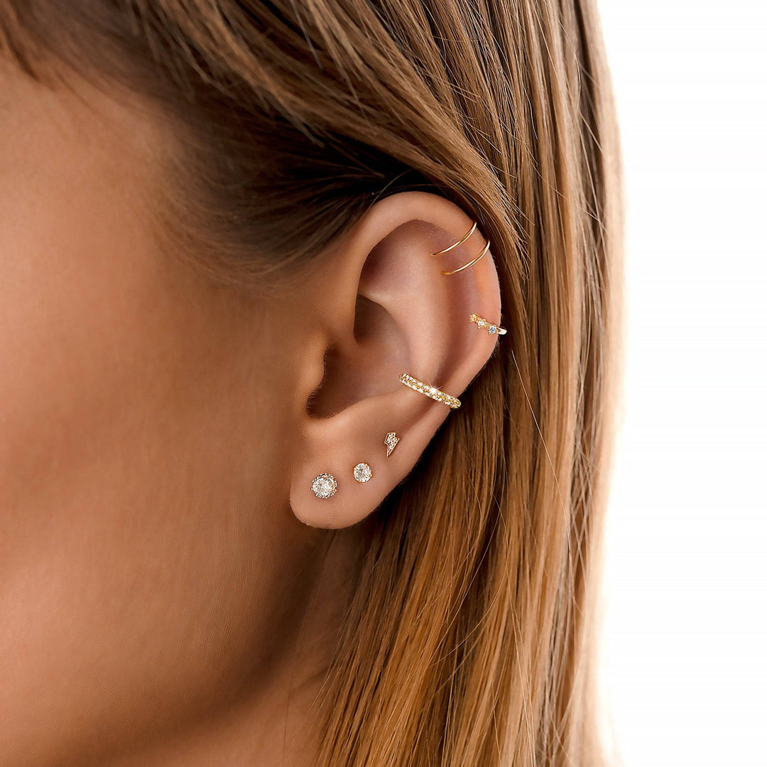 Frau mit goldenen Ohrringen und Piercings, Nahaufnahme, Schmuck, Modeaccessoires, stilvoll.