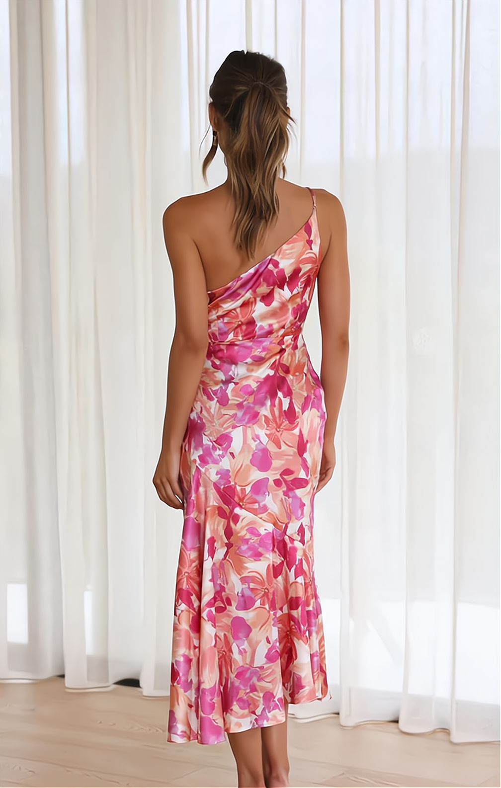 Frau in rosa, florales, schulterfreies Seidenkleid vor weißen Vorhängen, elegantes Abendkleid.