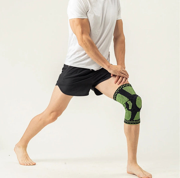Mann mit grün-schwarzer Kniebandage beim Dehnen, Sportbekleidung, Fitness, Unterstützung.