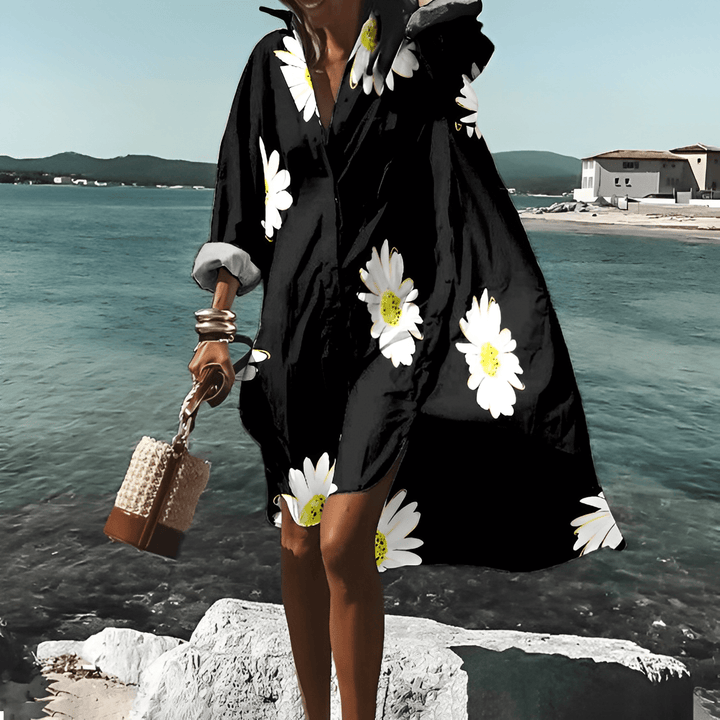 Frau in schwarzem, geblümtem, knielangem Kleid am Meer, Sommermode, Elle Vire.
