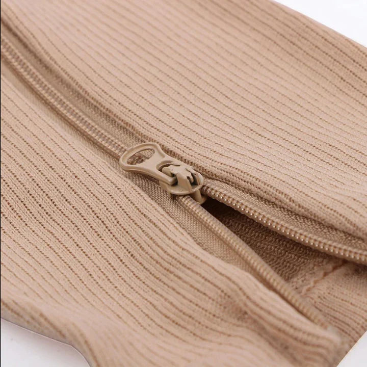 Beige Kompressionsstrumpf mit Reißverschluss, geripptes Material, Beinunterstützung, Schmerzlinderung.