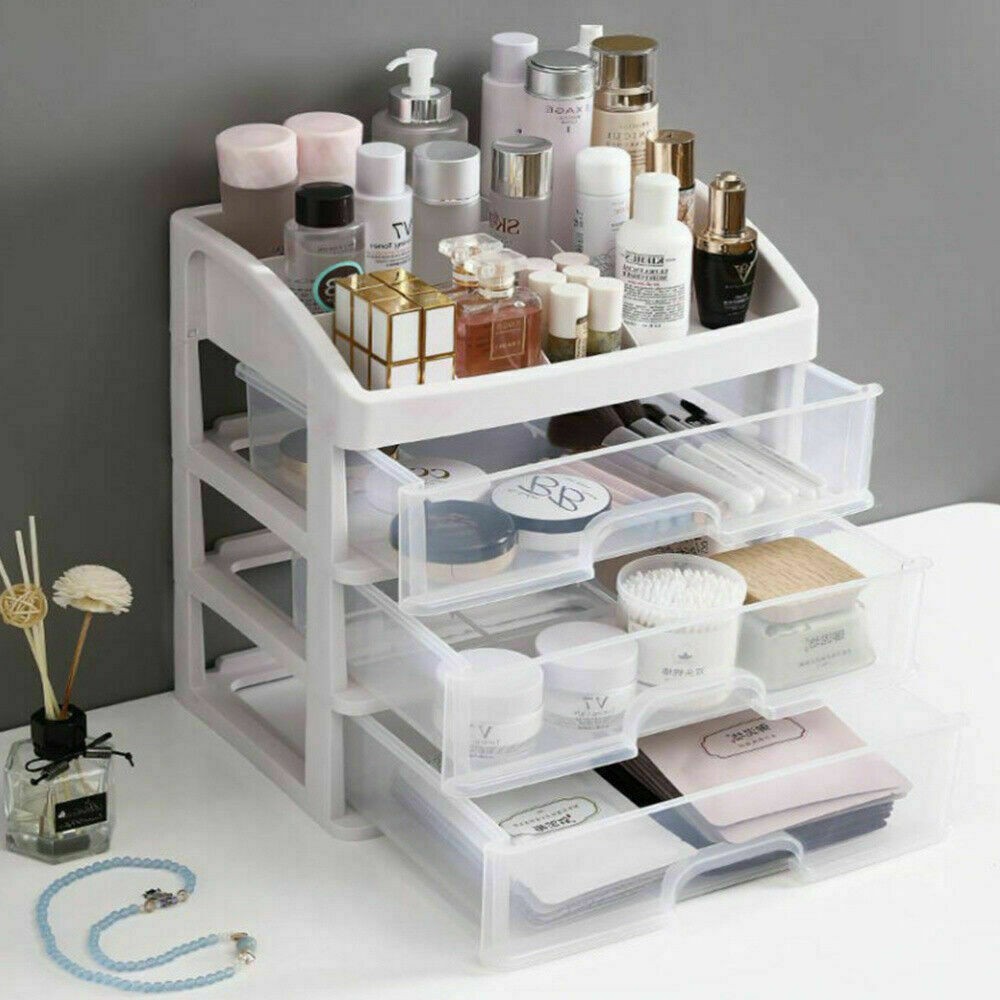 Weißer Kunststoff-Organizer mit Schubladen für Kosmetik und Pflegeprodukte auf grauem Hintergrund.