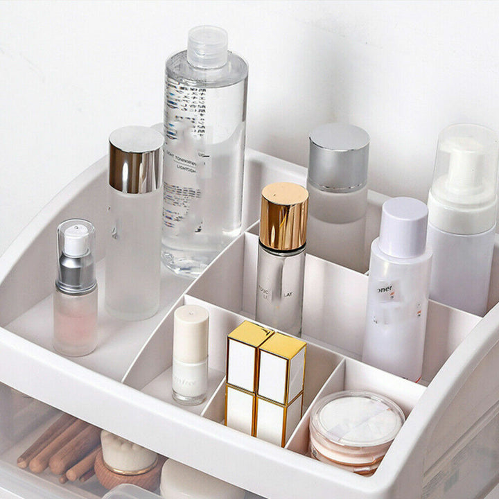 Kosmetik-Organizer aus Kunststoff, weiß, mit Fächern, gefüllt mit Hautpflege- und Make-up-Produkten.