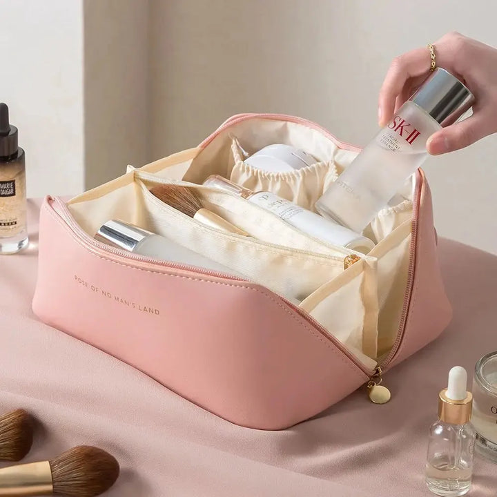 Rosa Kosmetiktasche aus Leder mit Pflegeprodukten, ideal für Reisen und Organisation.