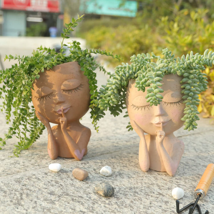 Zwei kreative Pflanzentöpfe in Form von Figuren mit Sukkulenten, Garten-Dekoration.