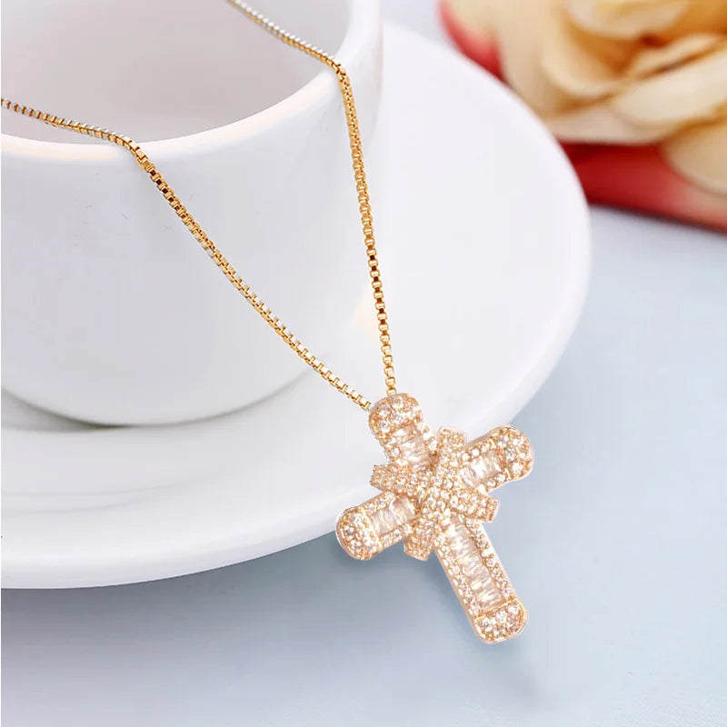 Goldene Kreuzkette mit Strasssteinen auf weißer Tasse, eleganter Schmuck, Geschenkidee.