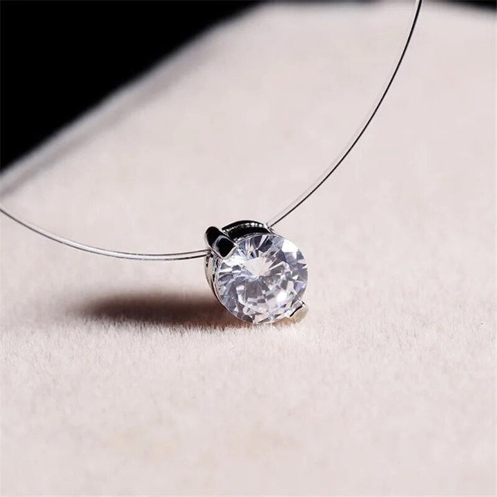 Klarer Kristallanhänger an zarter Halskette, eleganter Schmuck, funkelndes Accessoire.
