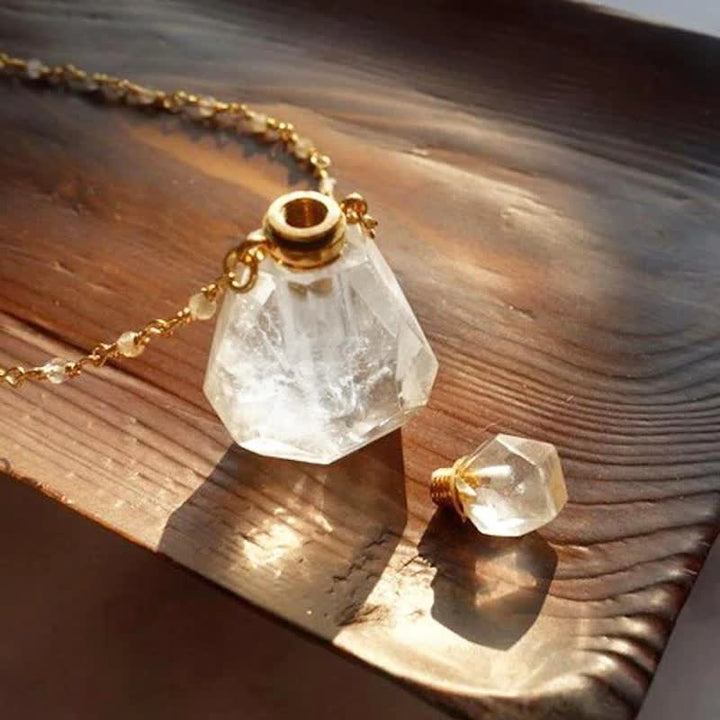 Klarer Kristallflakon mit goldener Kette auf Holz, Parfümflasche, elegantes Design.