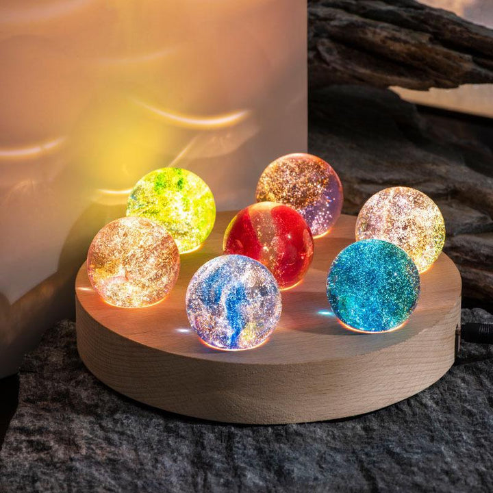 Sechs bunte Kristallkugeln auf Holzsockel, LED-Licht, dekorative Beleuchtung, modern.