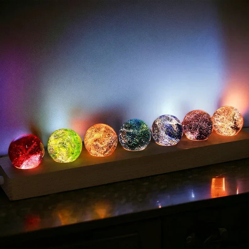 Bunte LED-Kristallkugeln auf Holzständer, stimmungsvolle Beleuchtung, Dekoration, Wohnzimmer.