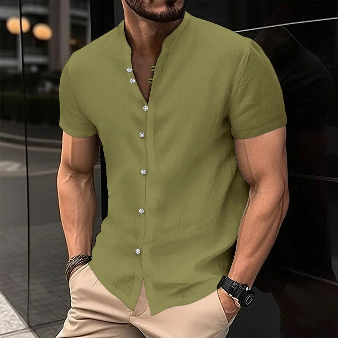 Mann in olivgrünem Leinenhemd mit Stehkragen, kurze Ärmel, Freizeitmode, Sommeroutfit.