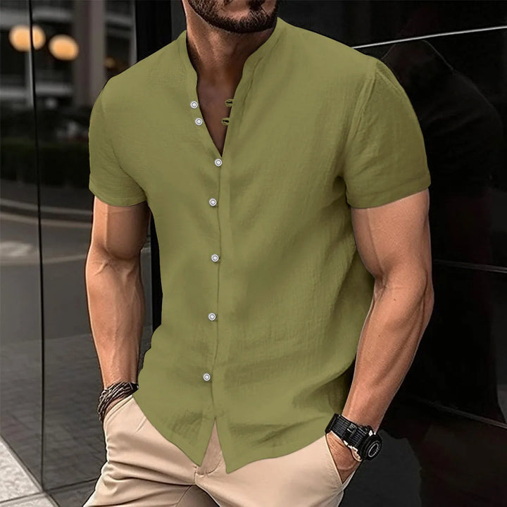 Mann in olivgrünem Leinenhemd mit Stehkragen, kurze Ärmel, Freizeitmode, Sommeroutfit.