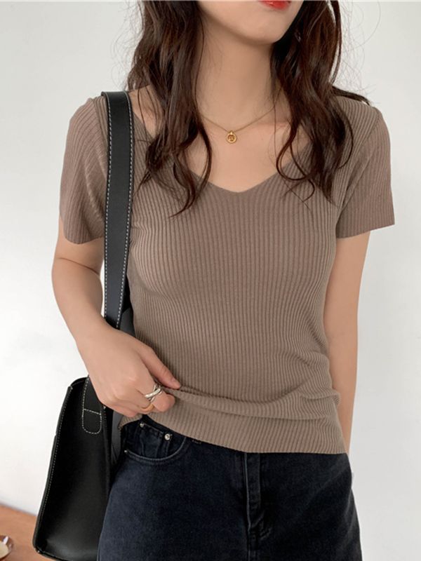 Frau in braunem, geripptem T-Shirt mit schwarzer Tasche, lässiger Look, Mode, Damenbekleidung.