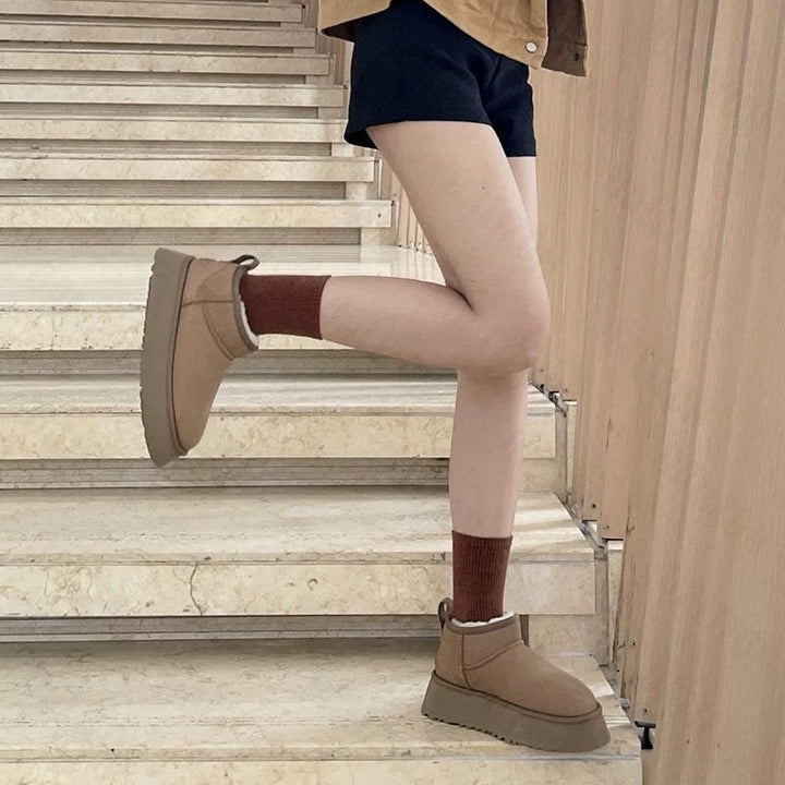 Damenstiefel beige, flach, runde Zehen, Wintermode, Treppe, braune Socken, lässiger Stil.