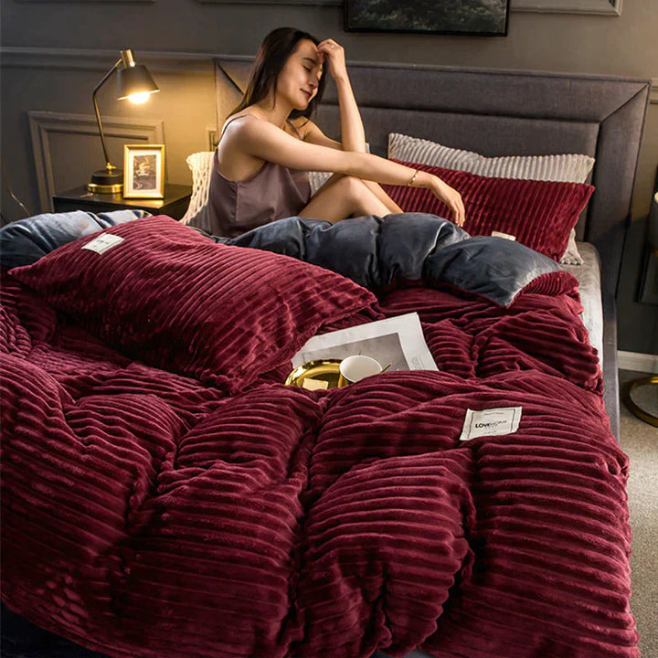 Frau auf Bett mit weinroter, gerippter Bettdecke, Kissen und Nachttischlampe im Schlafzimmer.