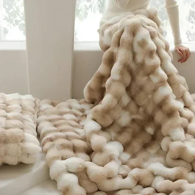 Luxuriöse beige Kunstpelzdecke auf Sofa, weiche Textur, gemütliche Wohnkultur, Winterwärme.