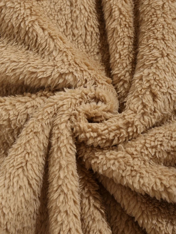 Brauner Plüschstoff, weiche Textur, ideal für Decken und Kleidung, gemütlich und warm.