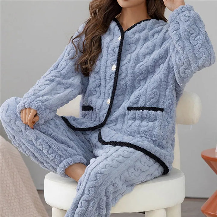 Frau in blauem Fleece-Pyjama-Set mit Knöpfen, gemütlich, warm, Winterkleidung, Wohnzimmer.