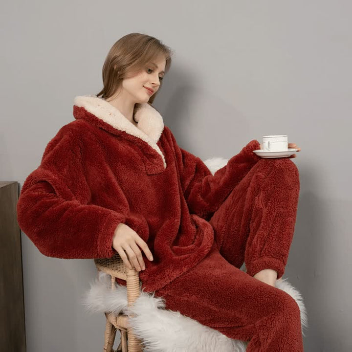 Frau in rotem Fleece-Pyjama mit Tasse, gemütliche Winterkleidung, weiches Material.