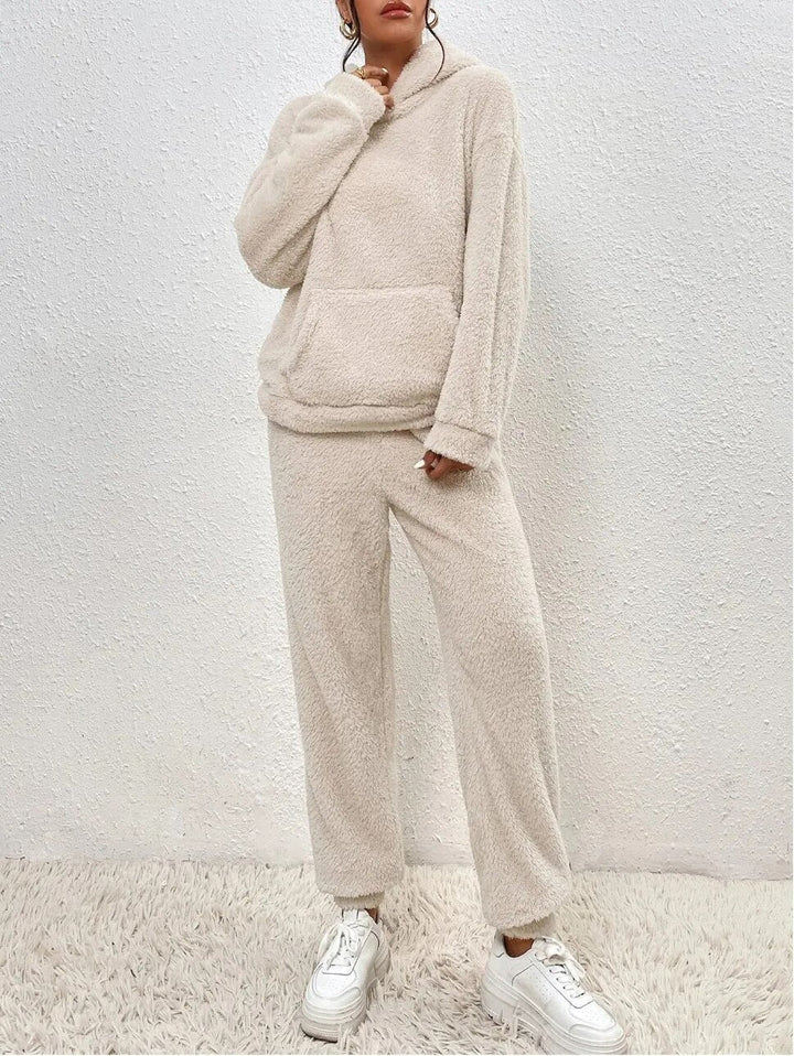 Frau in cremefarbenem Fleece-Set, Pullover und Hose, gemütlich, modisch, Herbst-Winter-Outfit.