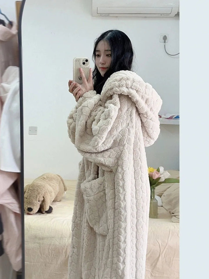 Frau im beigen, flauschigen Bademantel mit Kapuze, Selfie im Schlafzimmer, gemütliche Mode.