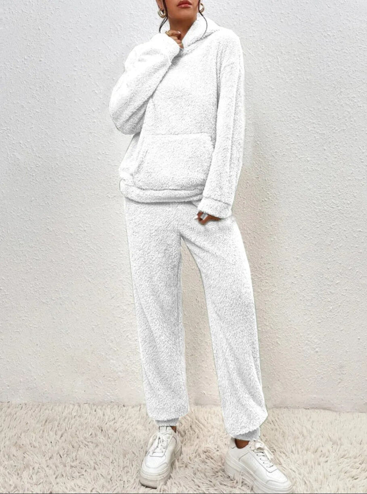 Frau in weißem Fleece-Hoodie und Jogginghose, gemütliche Wintermode, lässiger Stil.