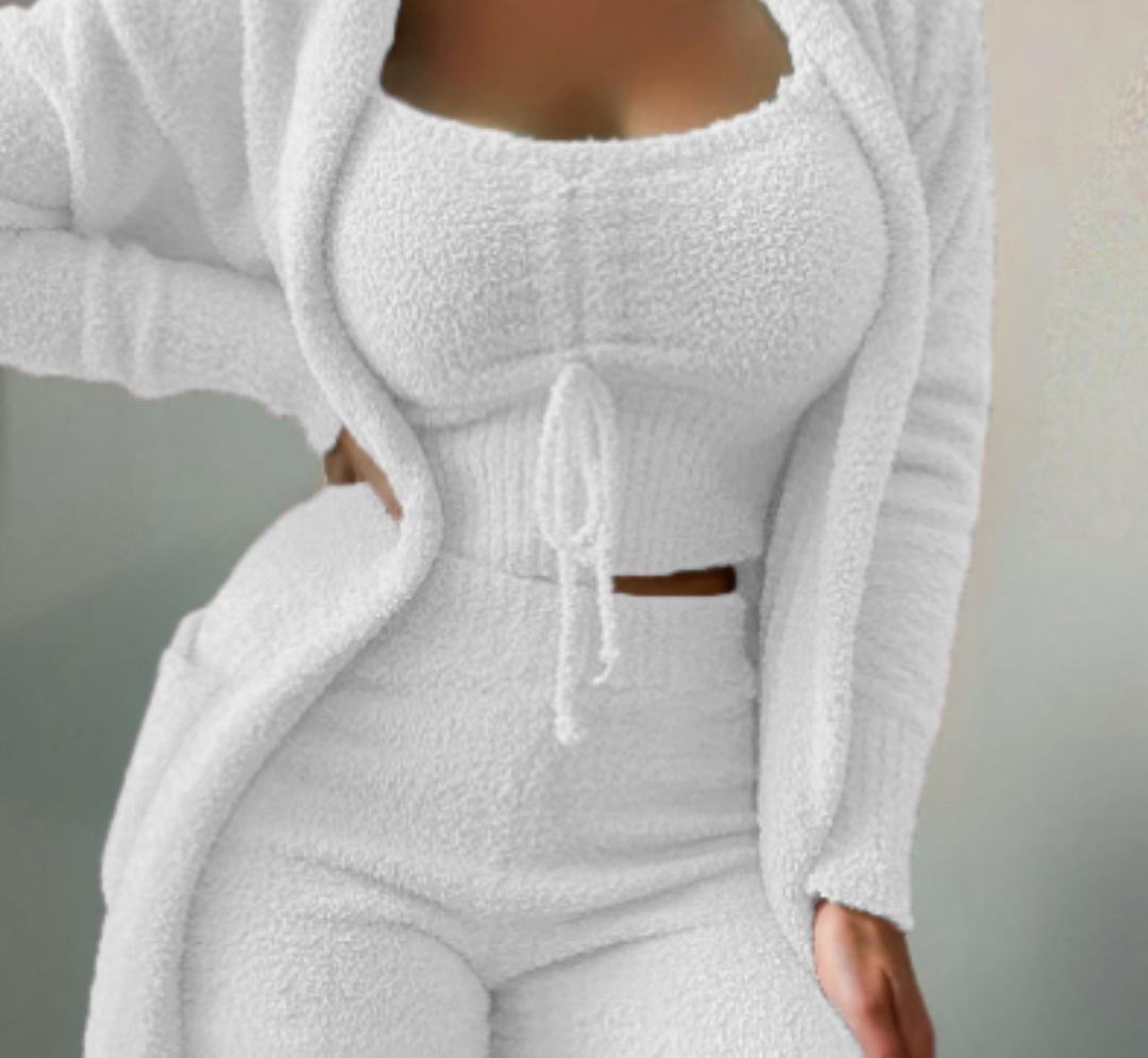 Frau in weißem Fleece-Loungewear-Set, bestehend aus Top, Hose und Cardigan.