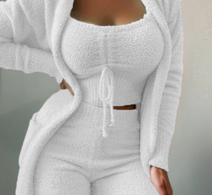Frau in weißem Fleece-Loungewear-Set, bestehend aus Top, Hose und Cardigan.