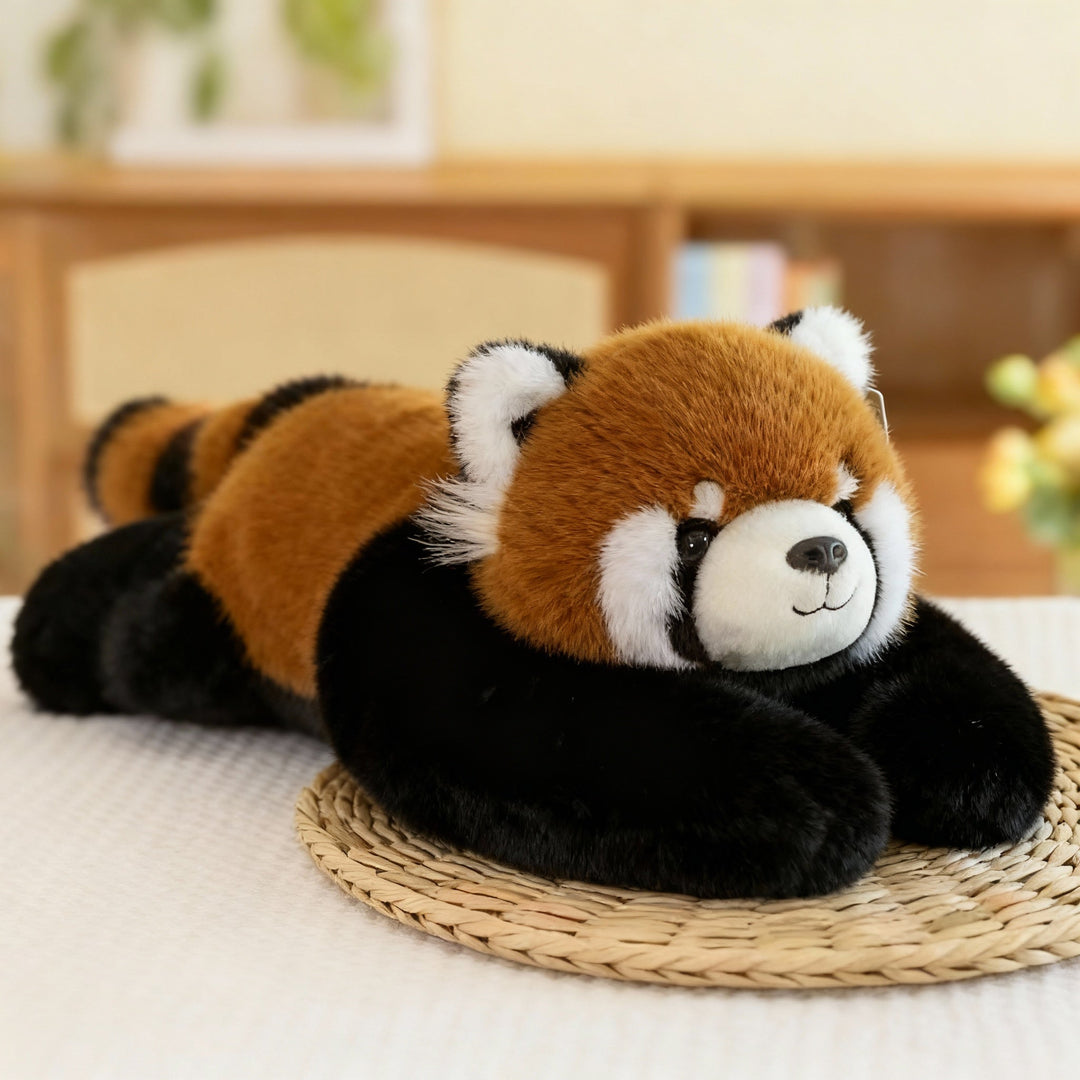 Plyšová panda červená s rezavou srstí, černýma nohama a dlouhýma pažema leží na slaměné podložce. 13