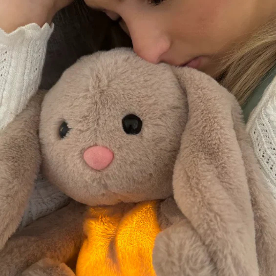 Frau kuschelt mit Plüschhase, leuchtend, beige, weiches Spielzeug, Trost, Wärme, Entspannung.