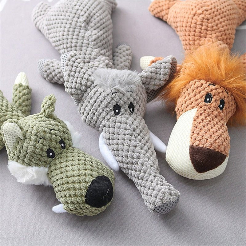 Drei gestrickte Plüschtiere: grüner Wolf, grauer Elefant, brauner Löwe auf grauem Hintergrund.