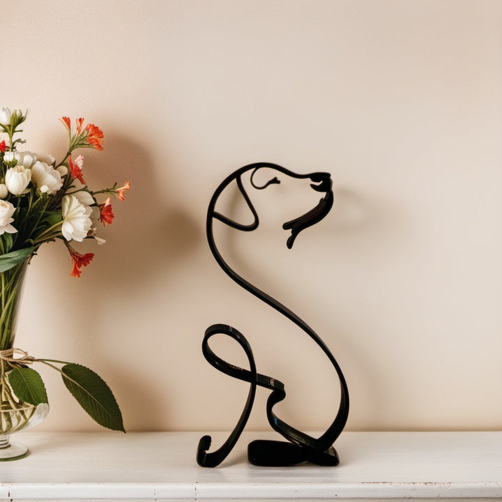 Schwarze Labrador-Skulptur aus Metall auf Regal, neben Blumenstrauß, moderne Deko.