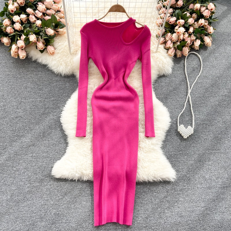Pinkes, figurbetontes Strickkleid, langärmelig, auf Teppich mit Rosen im Hintergrund.