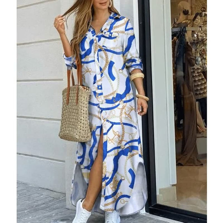 Frau in weißem Maxikleid mit blauem Kettenmuster, Strohtasche, weiße Sneaker, Sommermode.
