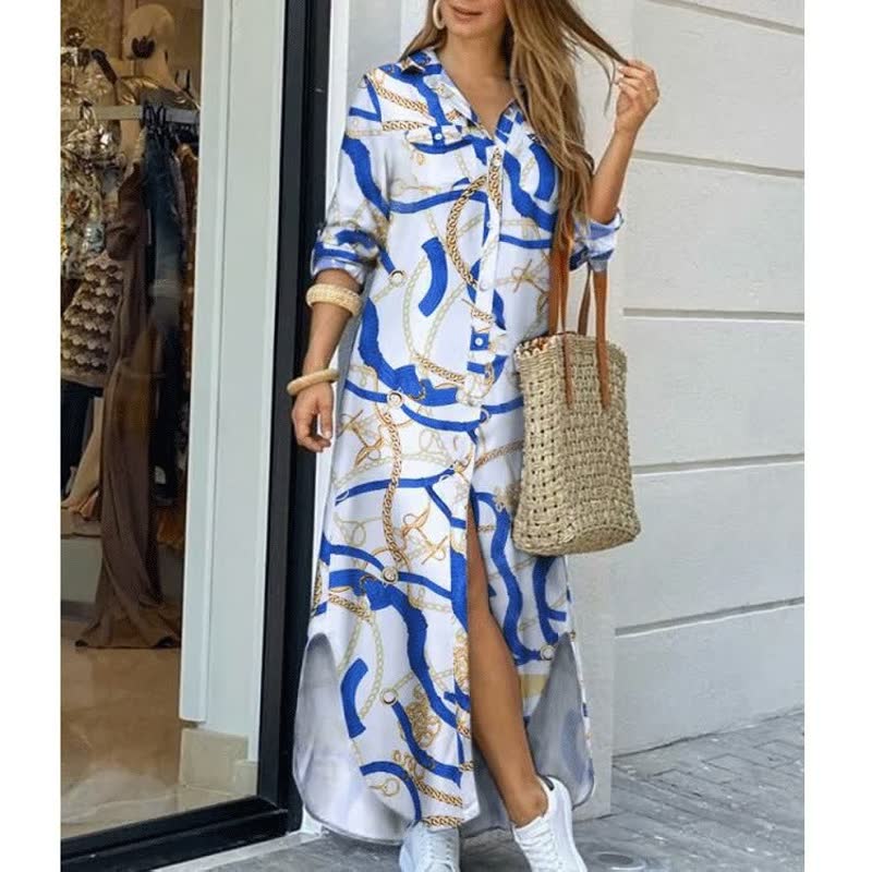 Frau in langem, gemustertem Hemdkleid mit blau-weißen Kettenmotiven, Strohtasche, weiße Sneaker.