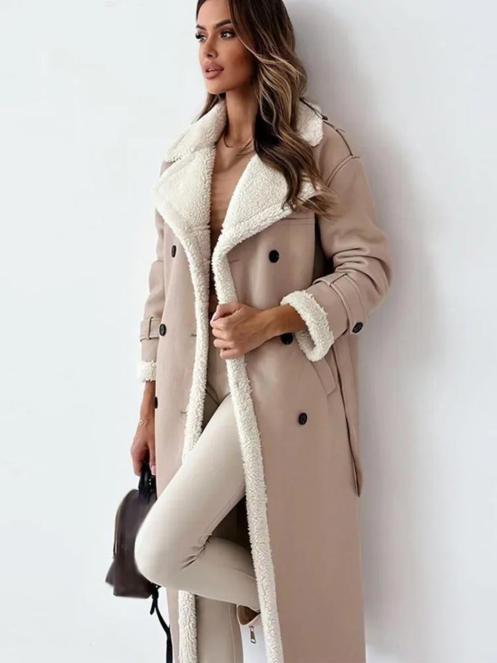 Frau in beiger Lammwoll-Lederjacke mit Gürtel, langen Ärmeln und Umlegekragen.