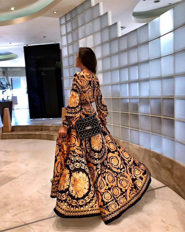 Frau in langem, gemustertem Kleid mit Tasche, modernes Interieur, elegantes Design.