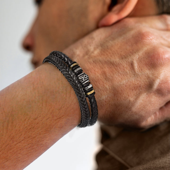 Schwarzes Lederarmband für Herren, geflochten, mit silbernen Details, modisches Accessoire.